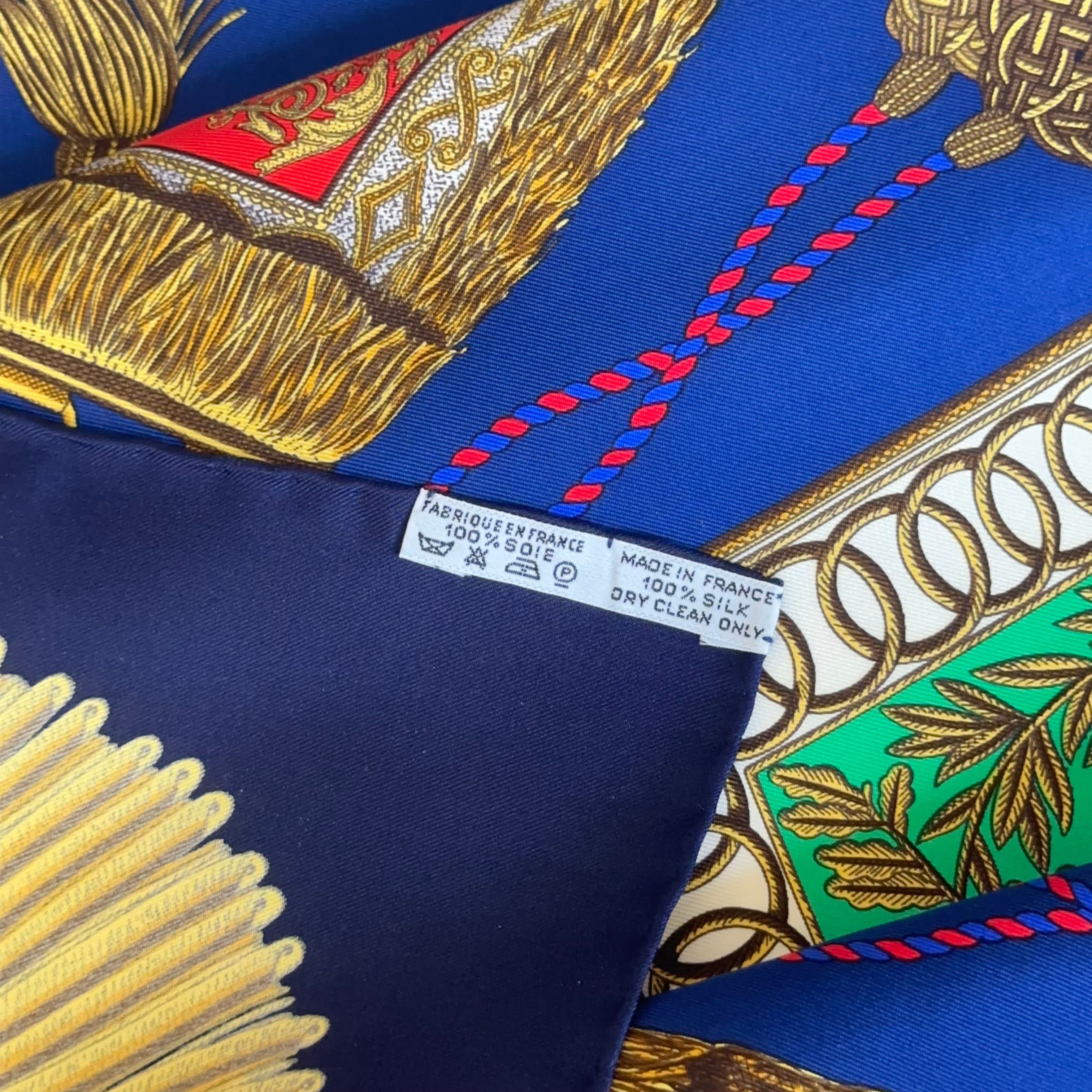 Détail de l'étiquette d'entretien "Made in France 100% Soie" cousue au dos, confirmant l'authenticité de ce carré vintage.