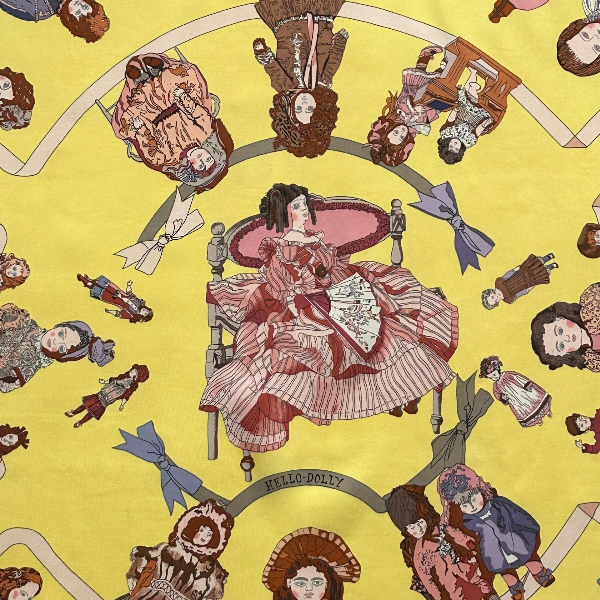 Zoom sur les poupées en costumes d'époque victoriens et rubans pastel sur fond jaune.