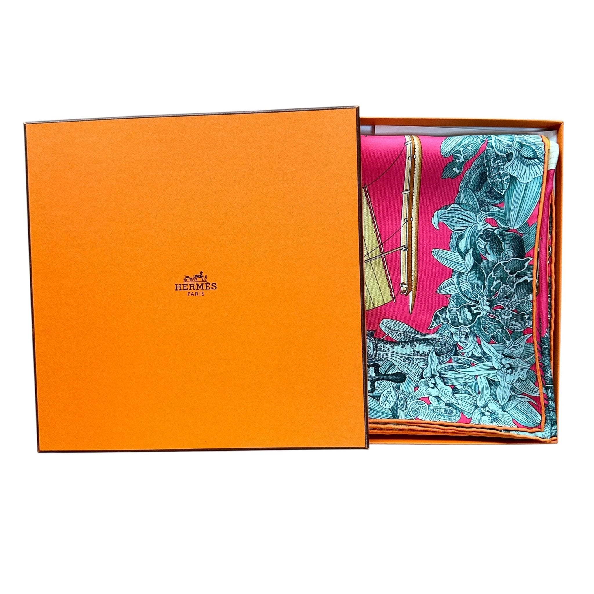 Le foulard Tous les Bateaux du Monde présenté dans sa boîte orange Hermès