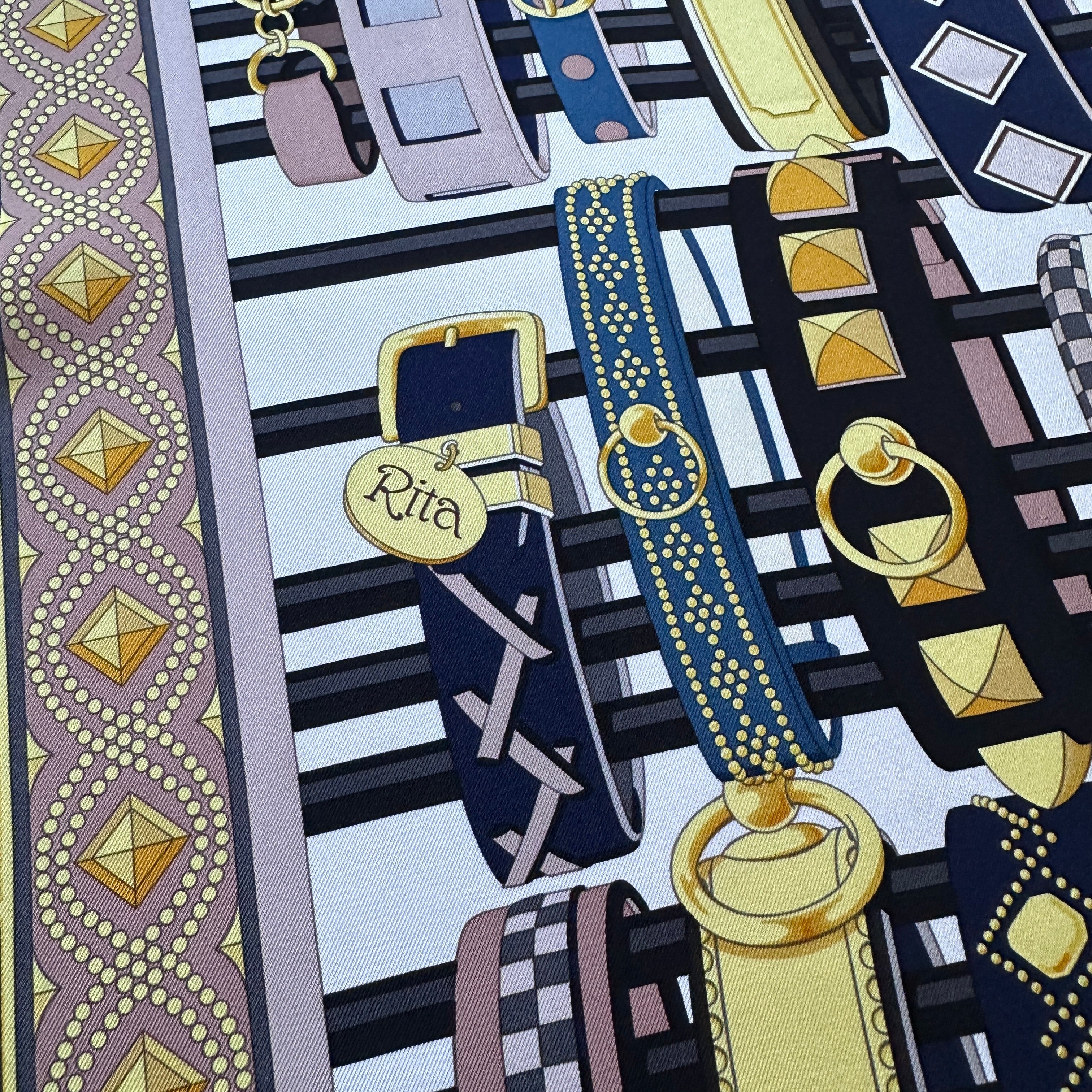 Zoom sur les détails de clous et médailles de colliers sur soie Hermès.