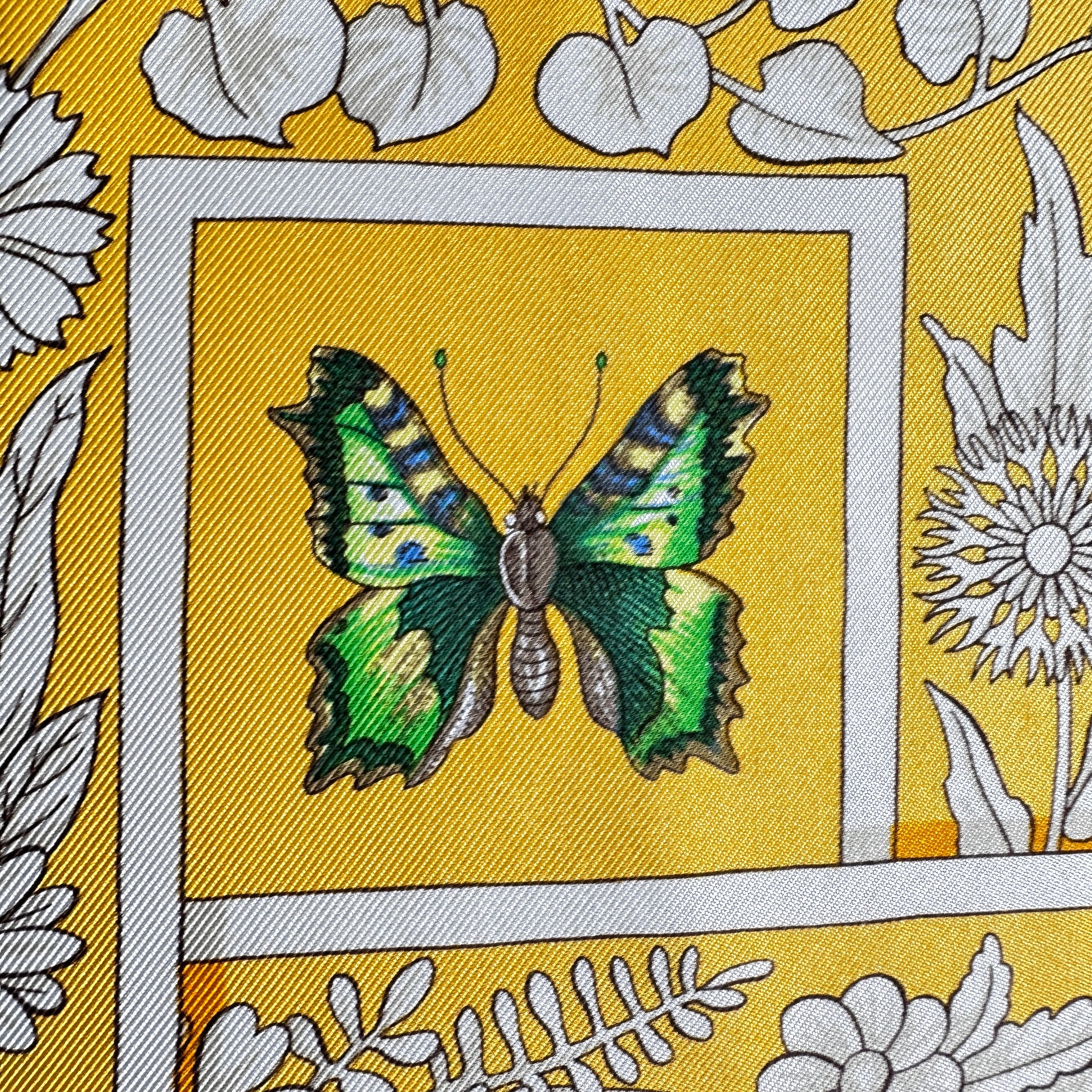 Gros plan sur un papillon vert dessinés sur la soie.